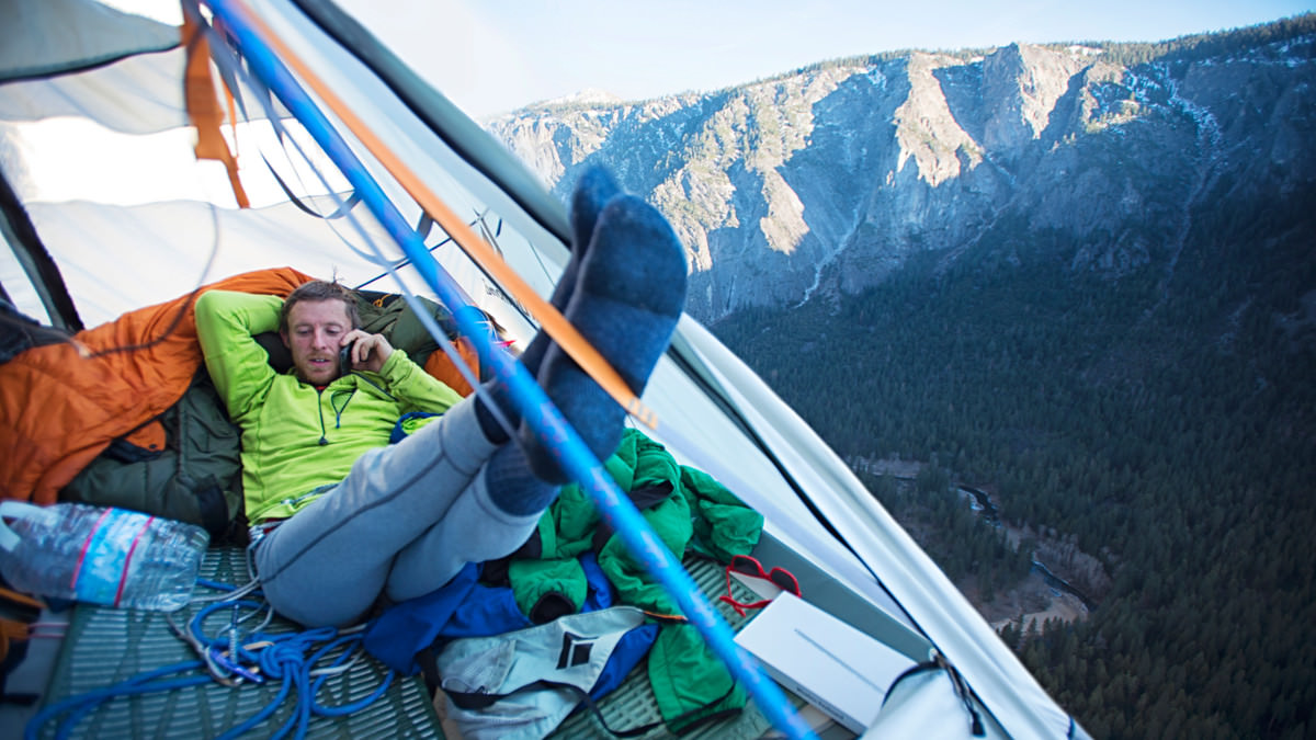 Томми Колдвелл (Tommy Caldwell) общается по мобильному телефону с группой помощи (обслуживания) в долине Йосемити. Таким образом команду снабжали провизией и снаряжением на всем времени восхождения. Когда же скалолазы вышли на вершину, Томми сказал в интервью New York Times, что обронил свой мобильник в низ примерно на середине маршрута и поэтому не мог ничего сообщать о себе долгое время. Его слова в долине транслировал Кевин. Photo: Corey Rich/Aurora Photos