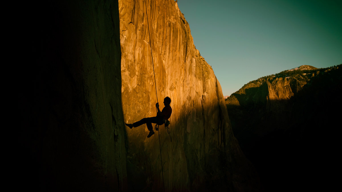 Заход солнца на Эль-Капитане. Томми Колдвелл (Tommy Caldwell) поднимается по перилам ... В целом же маршрут "Dawn Wall" был так назван из-за того, что первая часть маршрута освещается солнечными лучами в первой половине дня, в то время как вторая часть маршрута остается в тени. Photo: Corey Rich/Aurora Photos